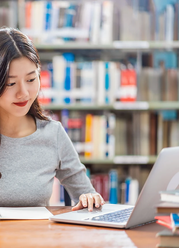 Content image - woman looking at laptop in library